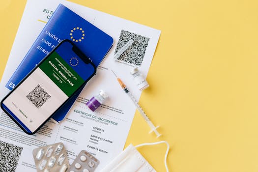 Digital vaccine passport and COVID-19 vaccination items including syringes and masks on a yellow background.